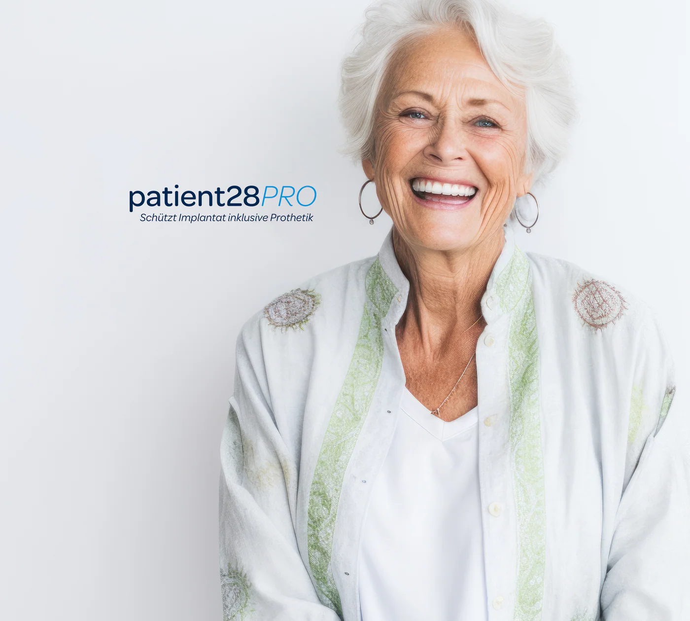 Lachende ältere Dame mit grauen Haaren zeigt ihre Zähne und trägt eine helle Bluse mit Muster.