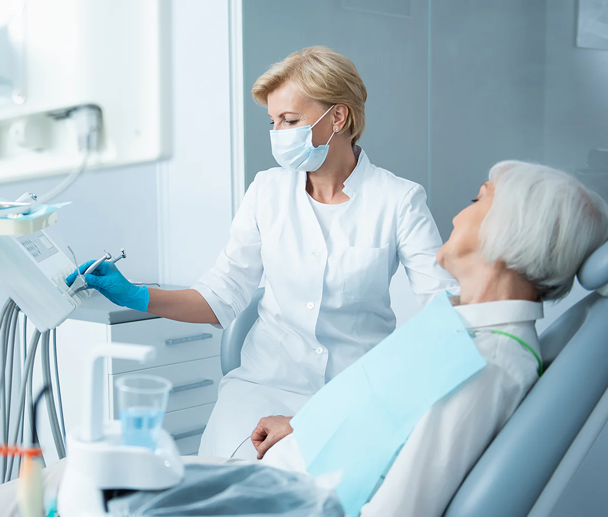 Zahnärztin führt eine Behandlung bei einer Patientin durch, während diese entspannt im Behandlungsstuhl sitzt.